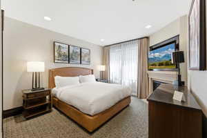 Carpeted room featuring recessed lighting and a window with sheer and blackout drapes