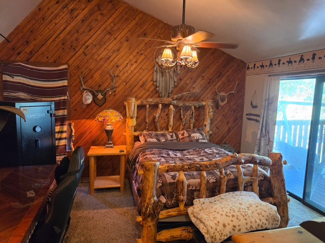 Vaulted ceiling featuring diagonal wood paneling and a ceiling fan with integrated lighting