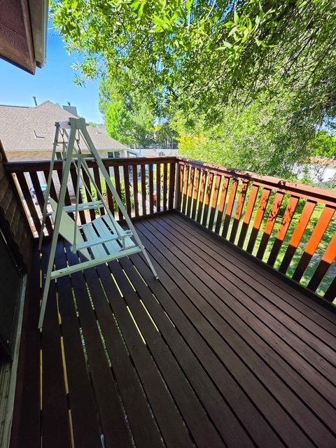 Upper-level deck featuring wood plank flooring and a wood railing