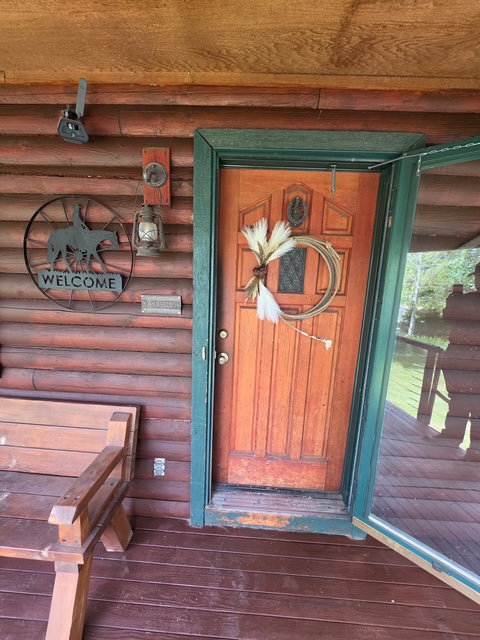 Wood-finish exterior with log siding and a wood-plank porch