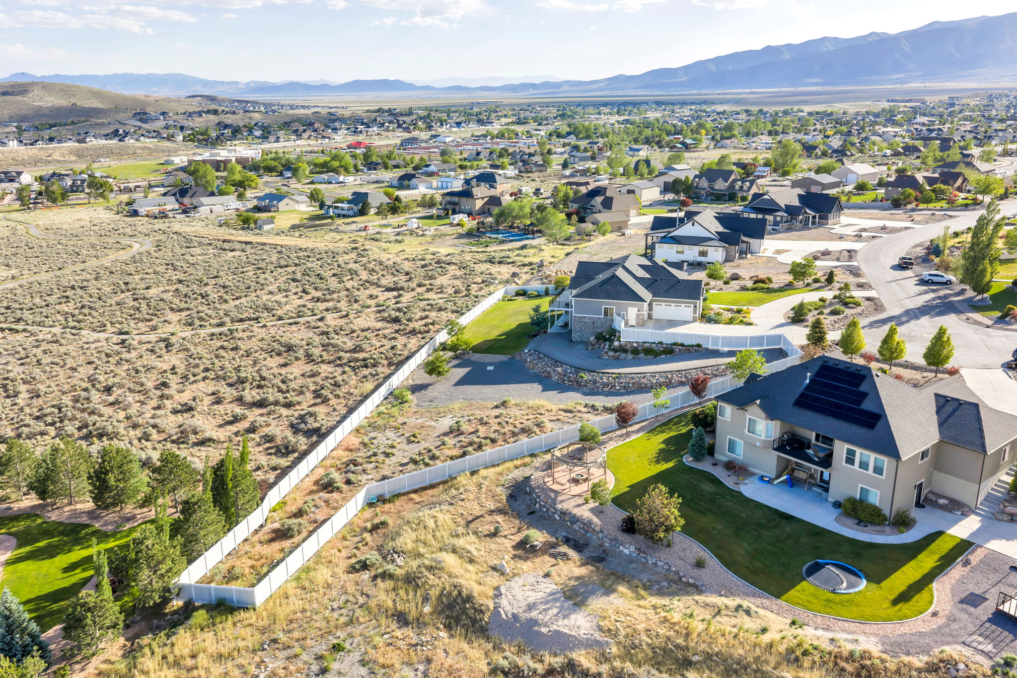 Expansive property featuring a large land parcel, established residential structures, mountainous terrain, and a suburban setting