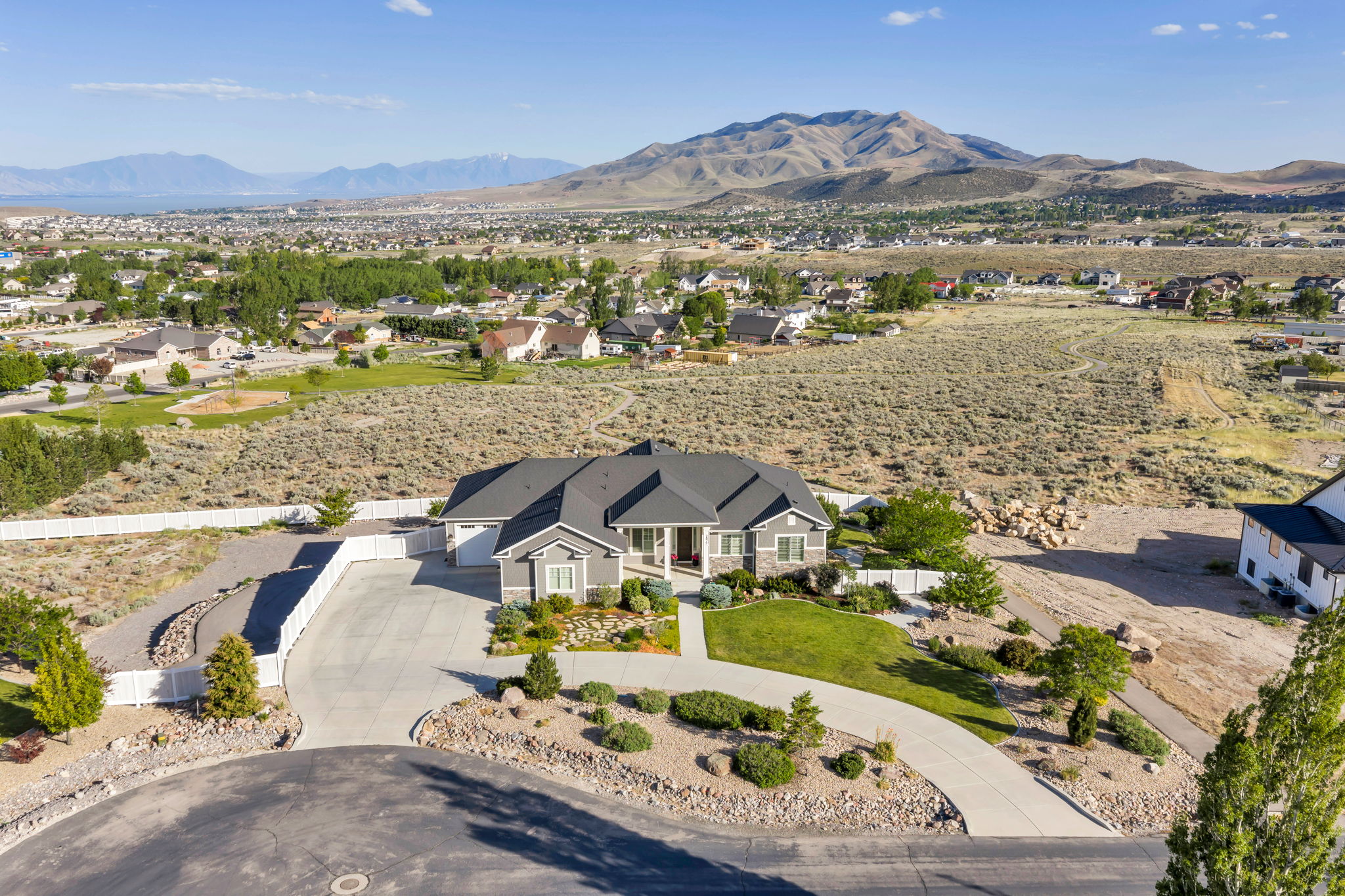 Ranch-style residence featuring a gray siding exterior, dark shingle roof, and an attached two-car garage