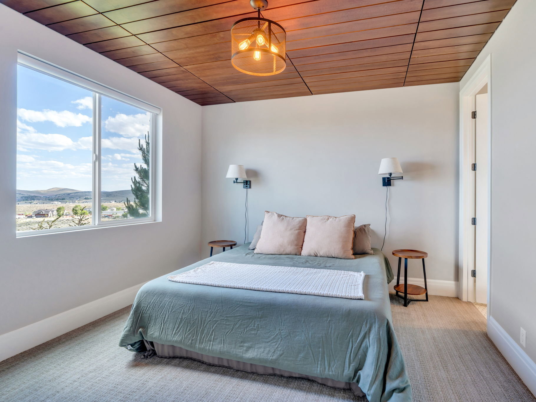 Recessed wood panel ceiling featuring a modern caged chandelier