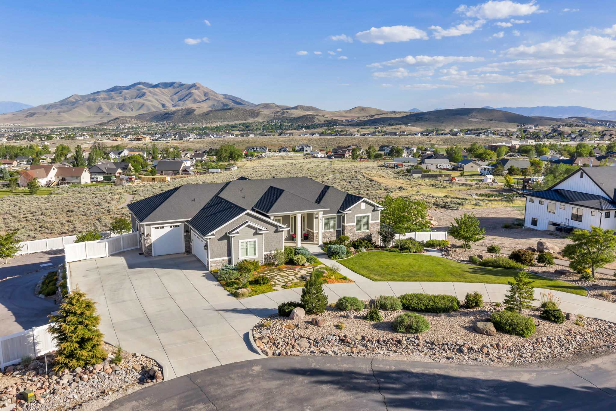 Ranch-style residence featuring a multi-gable roofline, a two-car garage, and a covered entry porch
