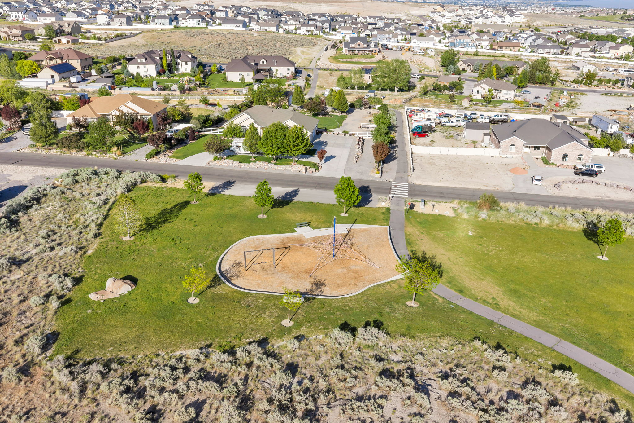Community park with a dedicated playground area, paved walking paths, and mature landscaping