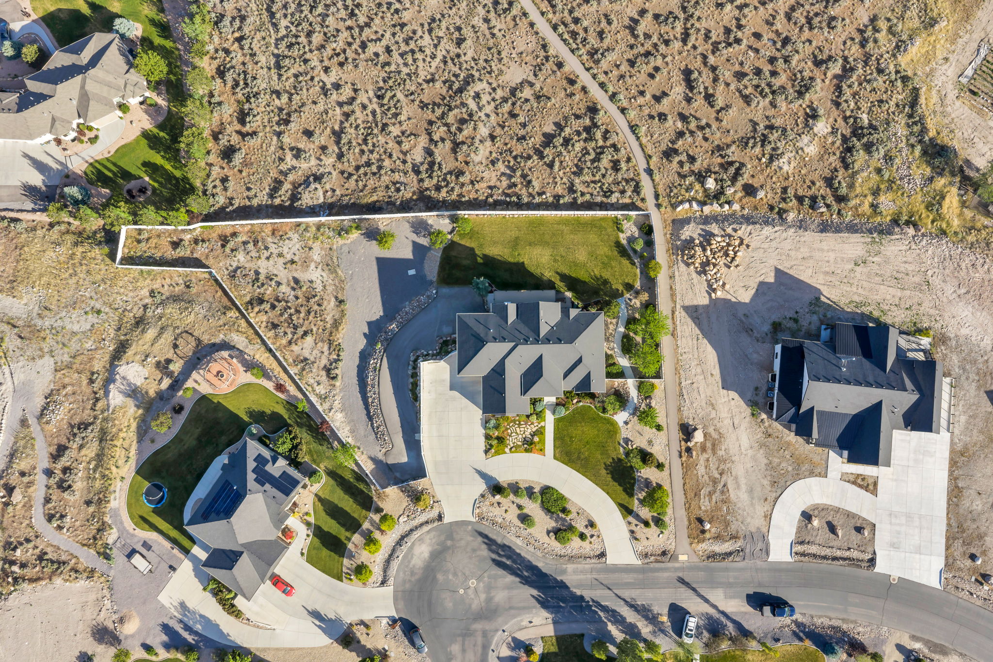 Aerial view of a residential property featuring a gray shingle roof and a concrete driveway