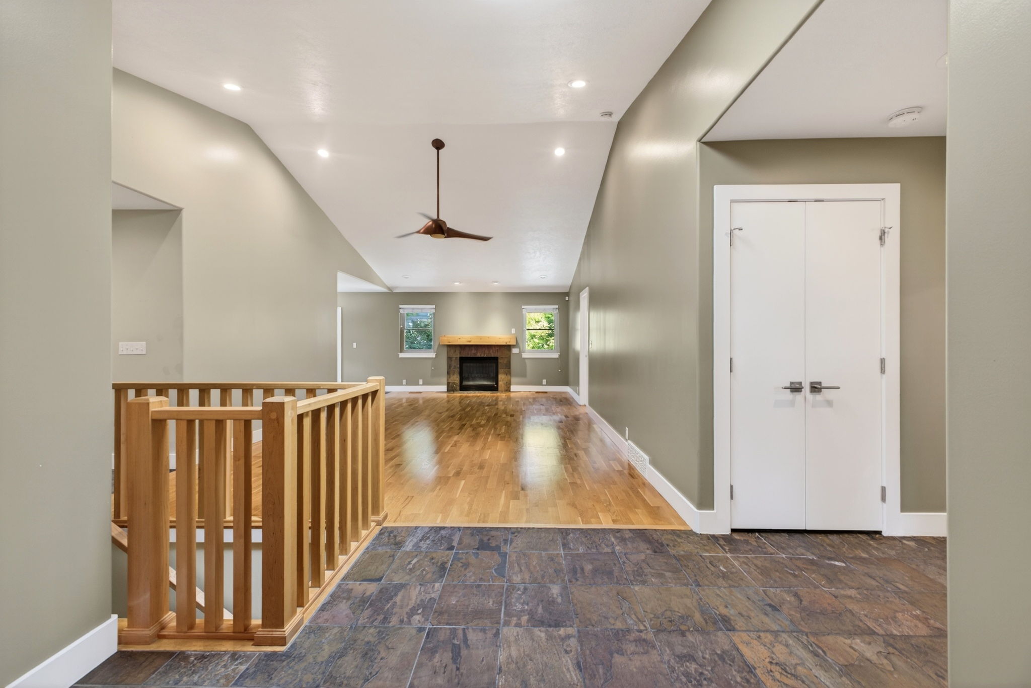 Foyer featuring slate tile flooring and a light wood staircase railing