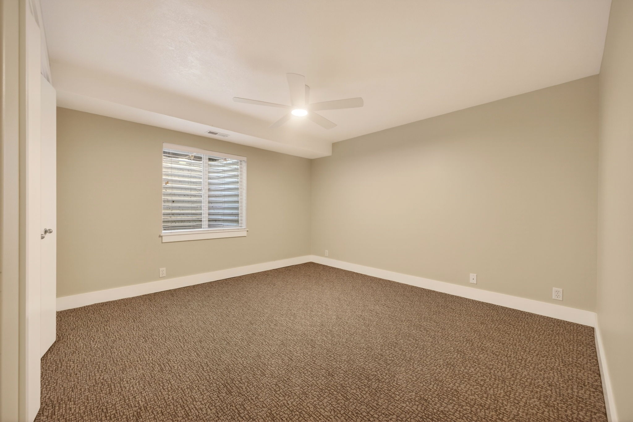 Bedroom featuring a ceiling fan and neutral tones