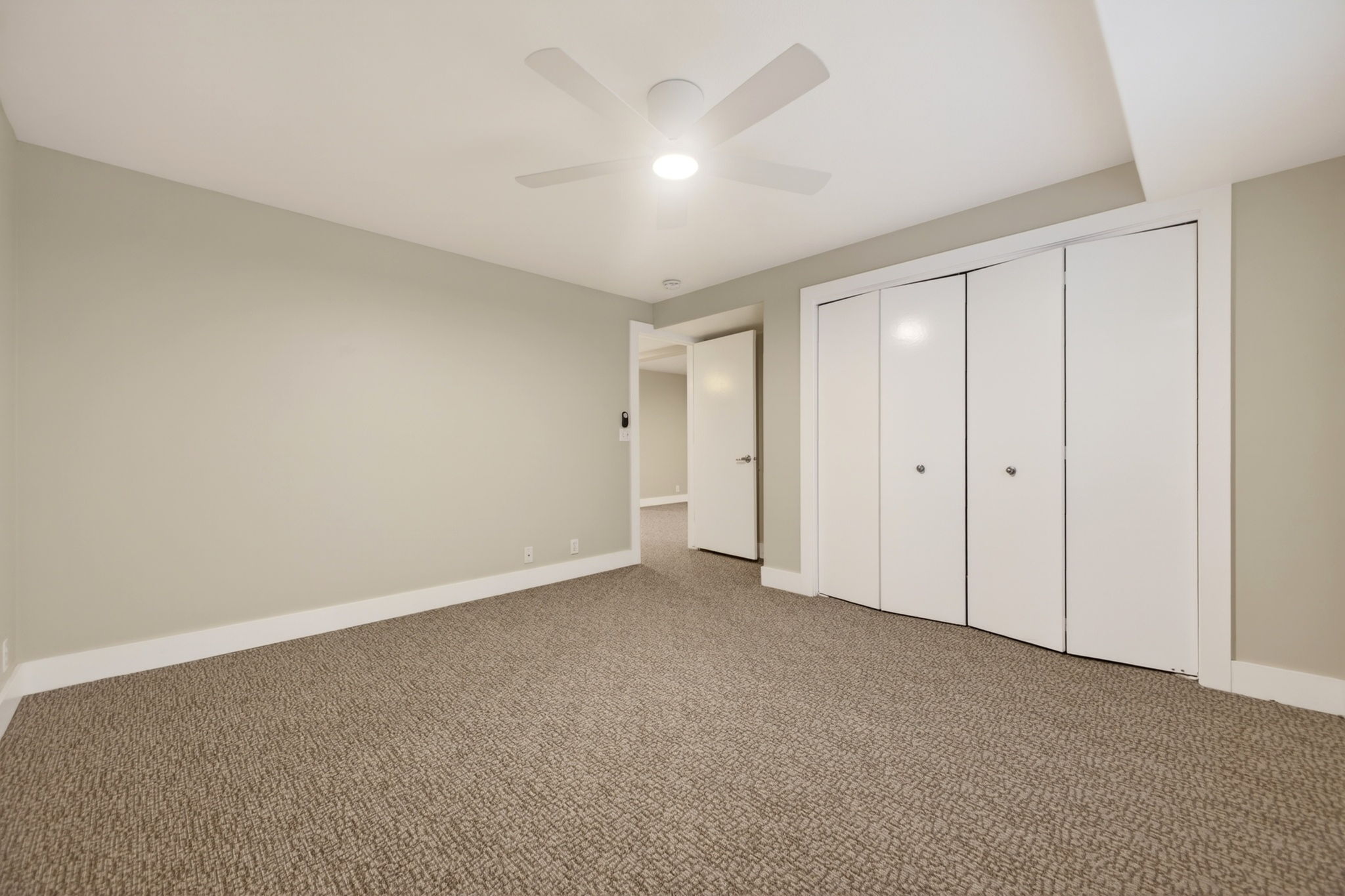 Spacious bedroom featuring large closet and ceiling fan