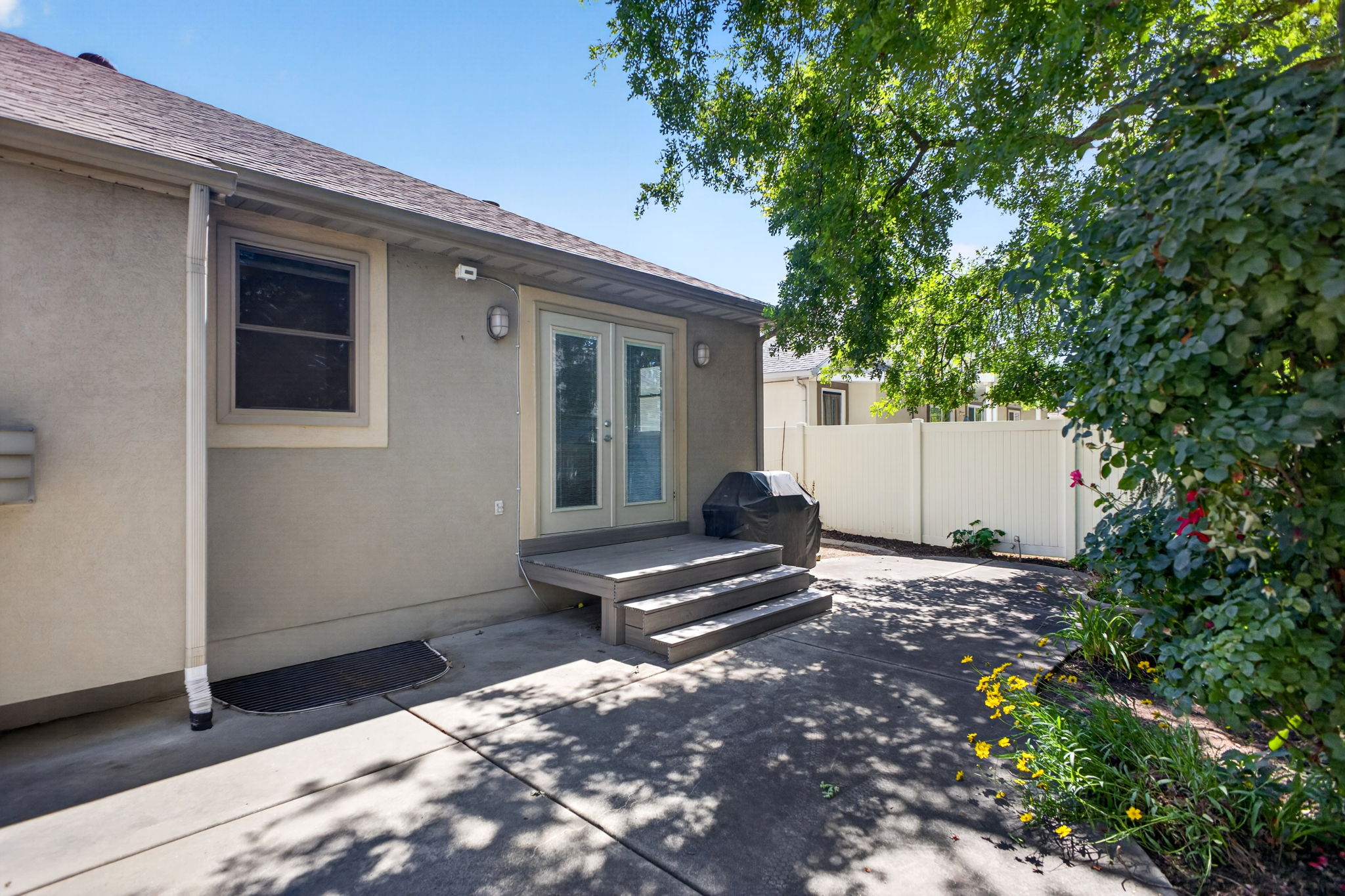Concrete patio with steps leading to double glass doors