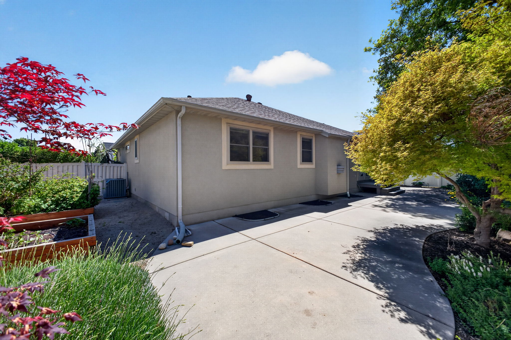 Fully fenced backyard with white vinyl fencing and mature trees