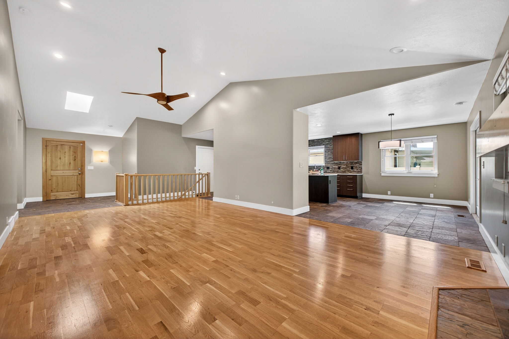 Open-concept living area featuring vaulted ceilings, a skylight, and recessed lighting