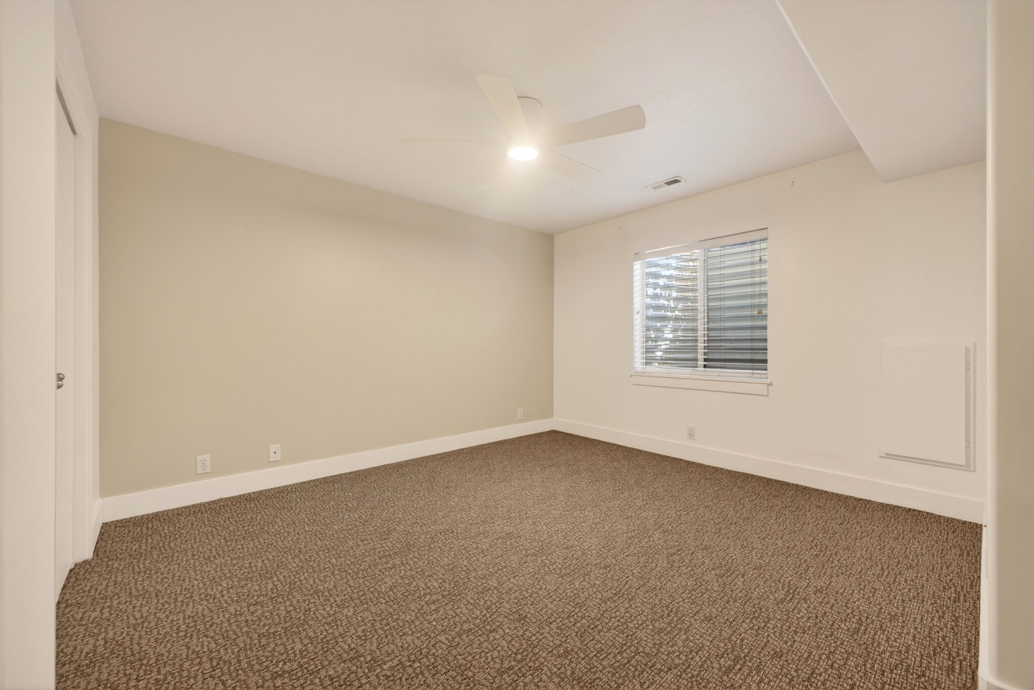 Bedroom with window, ceiling fan, and neutral tones