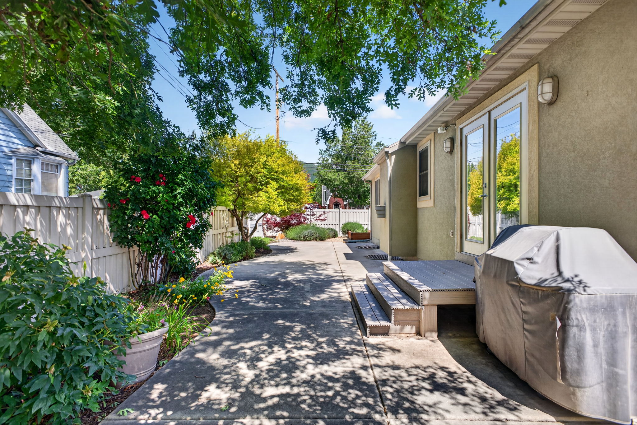 Backyard featuring dual French doors, and a wood-plank deck, and included gas grill
