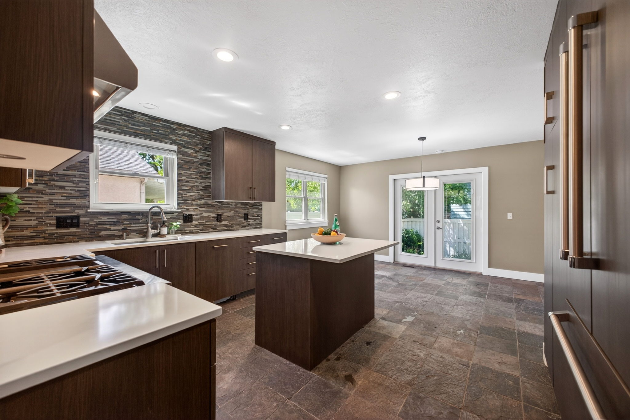 Kitchen featuring dark wood-finish cabinetry, eat in island with storage, and built-in refrigerator