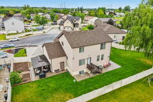 Expansive rear yard featuring a privacy fence, manicured lawn, and mature trees