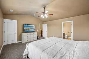 Carpeted room featuring a vaulted ceiling and a ceiling fan with light fixture