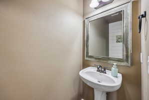 Pedestal sink with a two-handle faucet, set against a neutral-toned wall