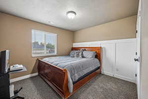 Carpeted room featuring a window with blinds, board and batten wall paneling, and an overhead light fixture
