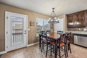 Dining area with tile flooring and a multi-light chandelier