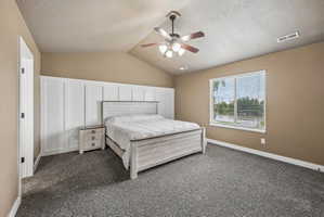 Room featuring vaulted ceilings with a ceiling fan, plush carpet flooring, and a large window with horizontal blinds