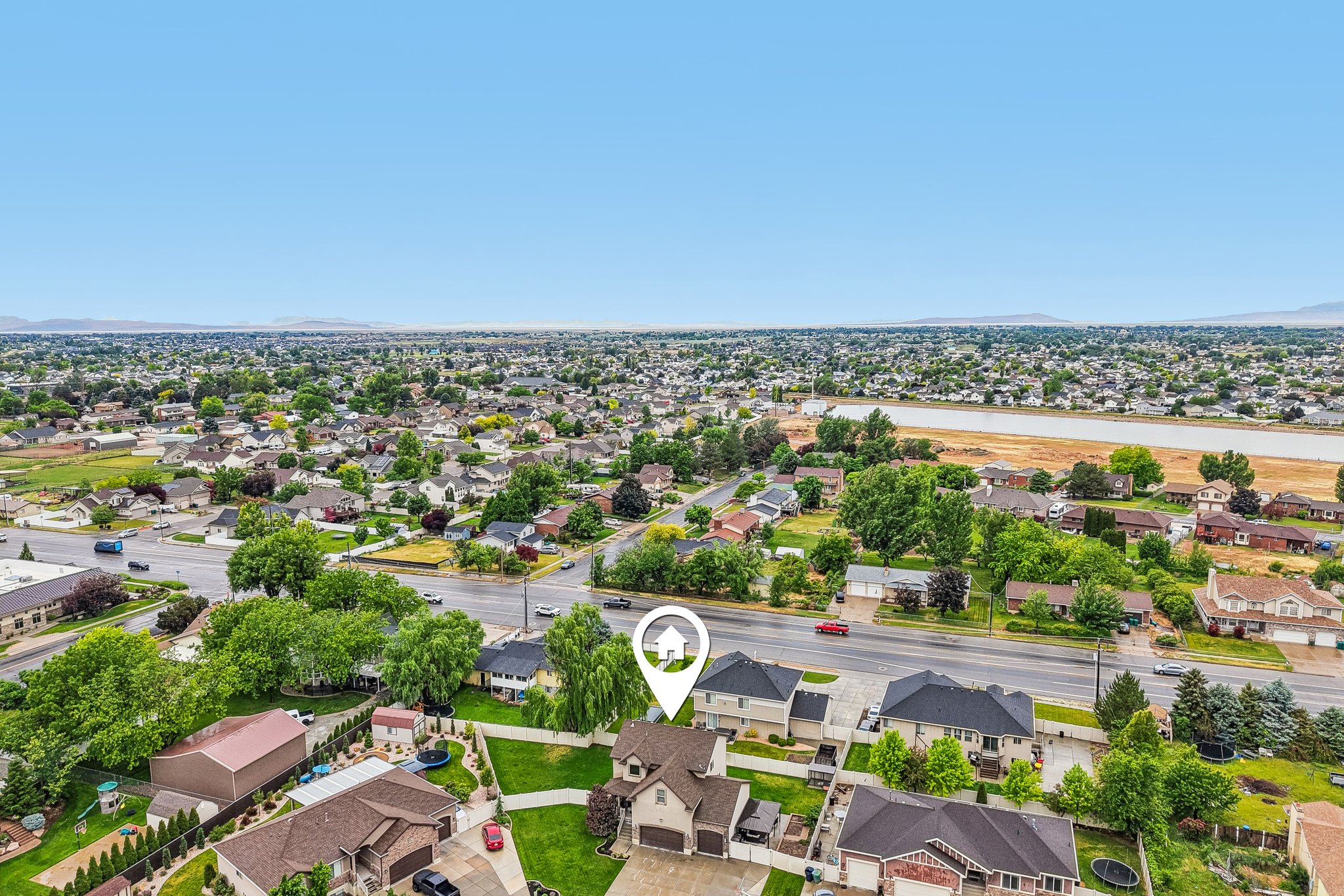 Aerial perspective showcasing a residential neighborhood with established trees and surrounding natural elements