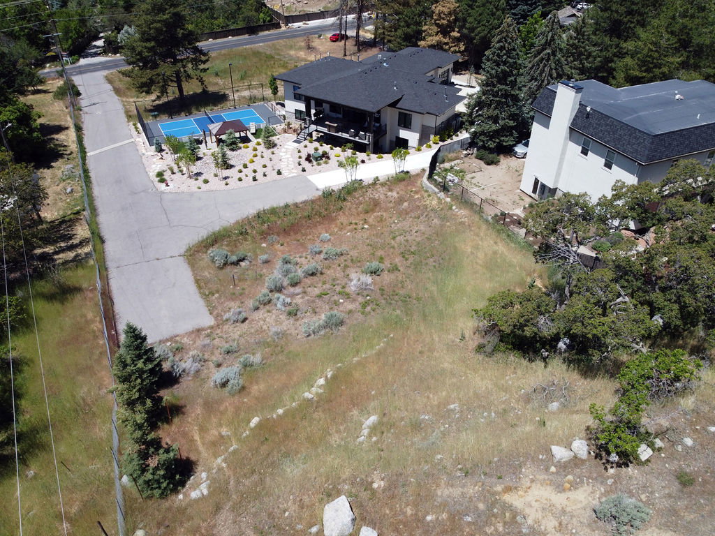 Expansive land parcel featuring natural landscaping with scattered trees and shrubs