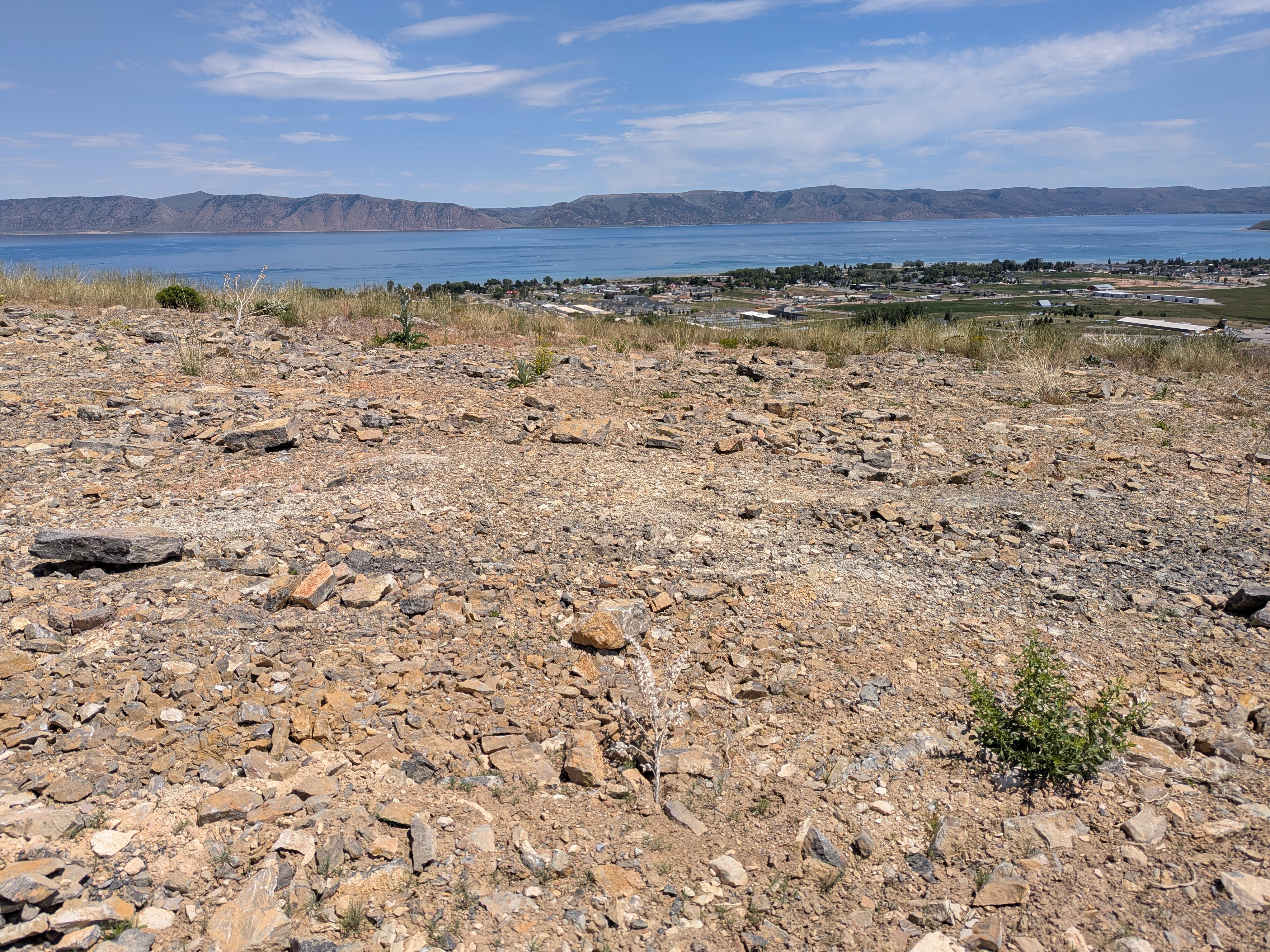 Elevated building lot featuring natural rock formations and distant water scenery