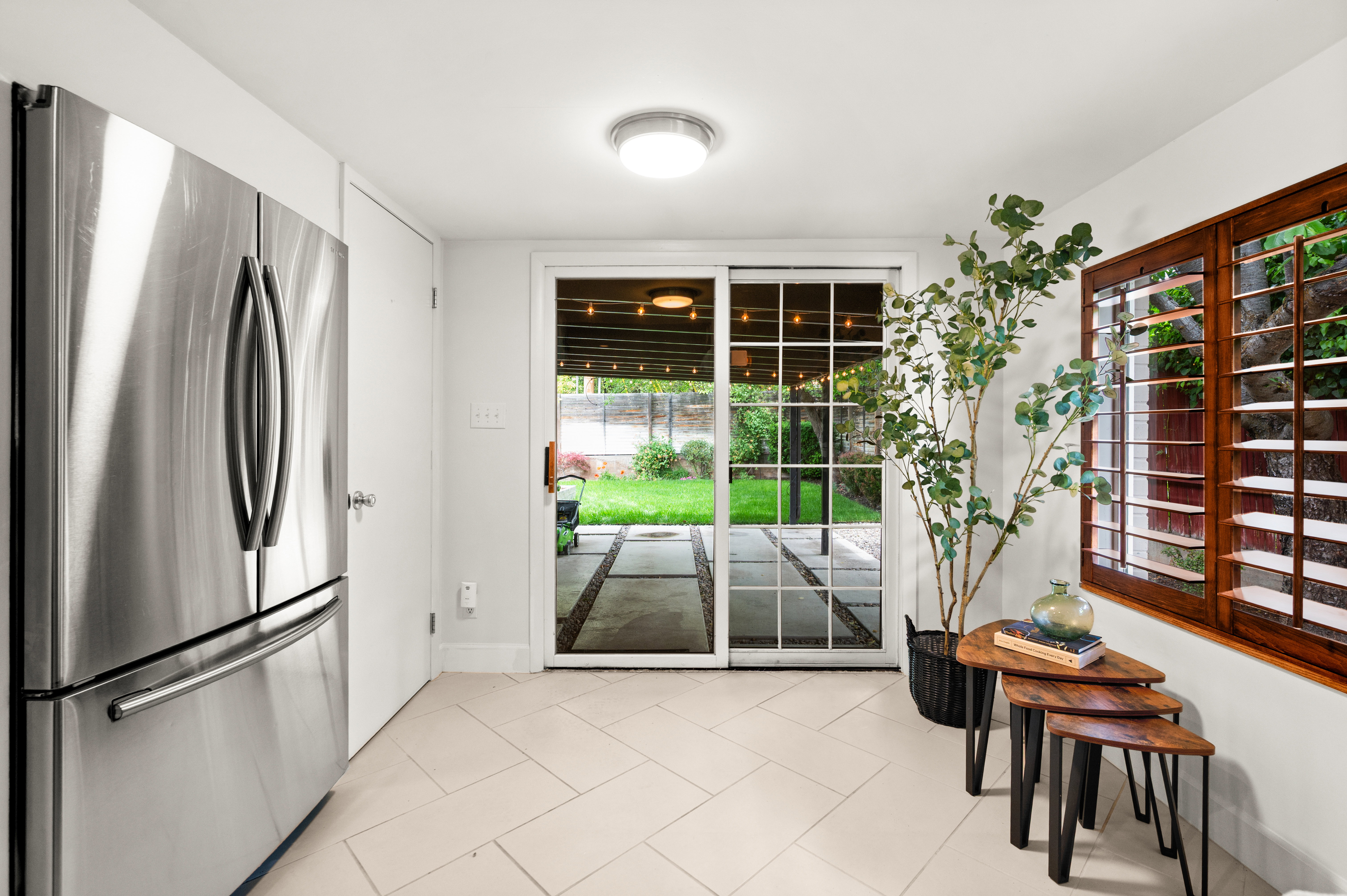 Kitchen space featuring light-toned tile flooring and a stainless steel refrigerator