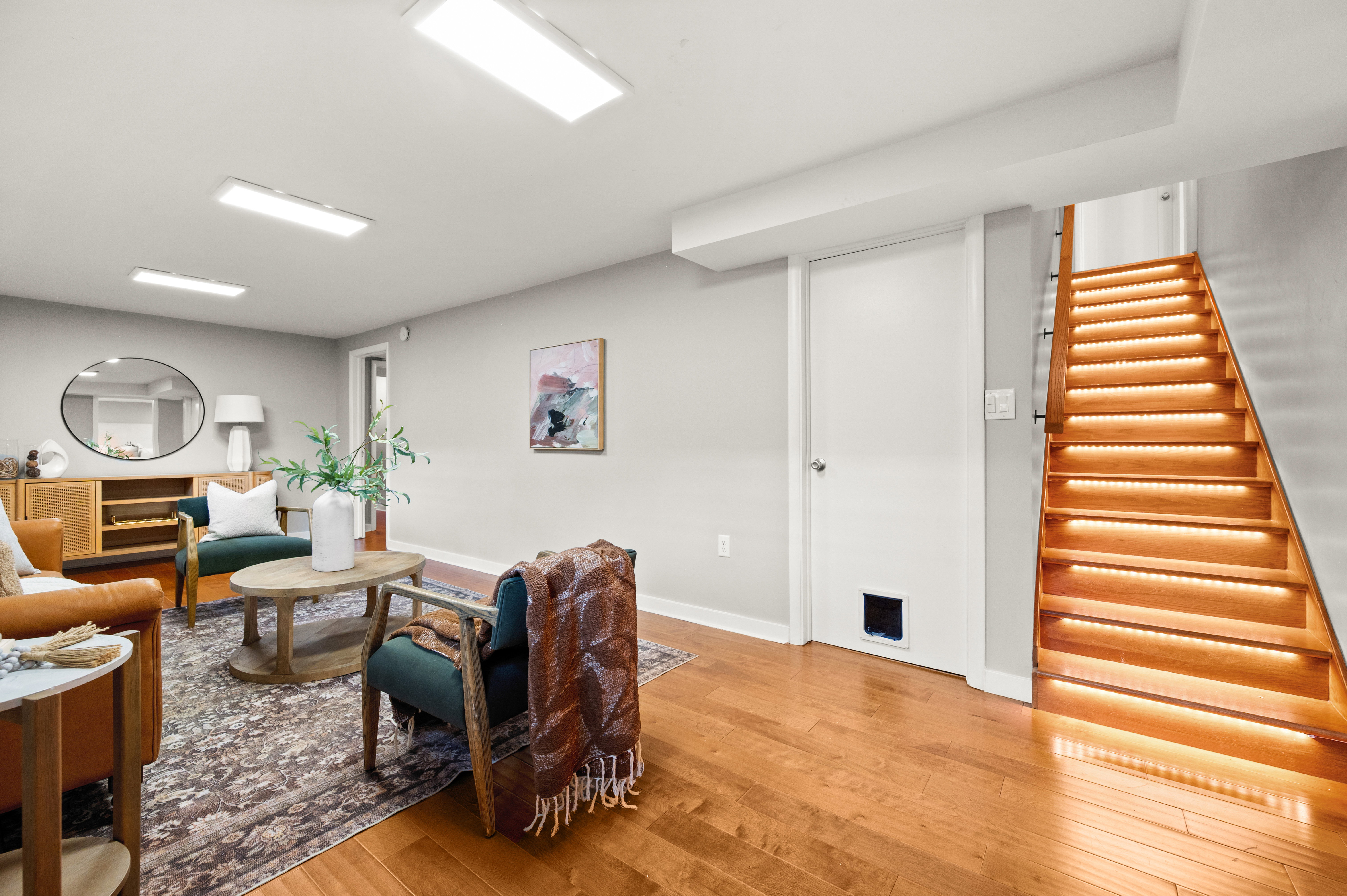 Hardwood flooring spanning the room, complemented by a contemporary light gray wall color