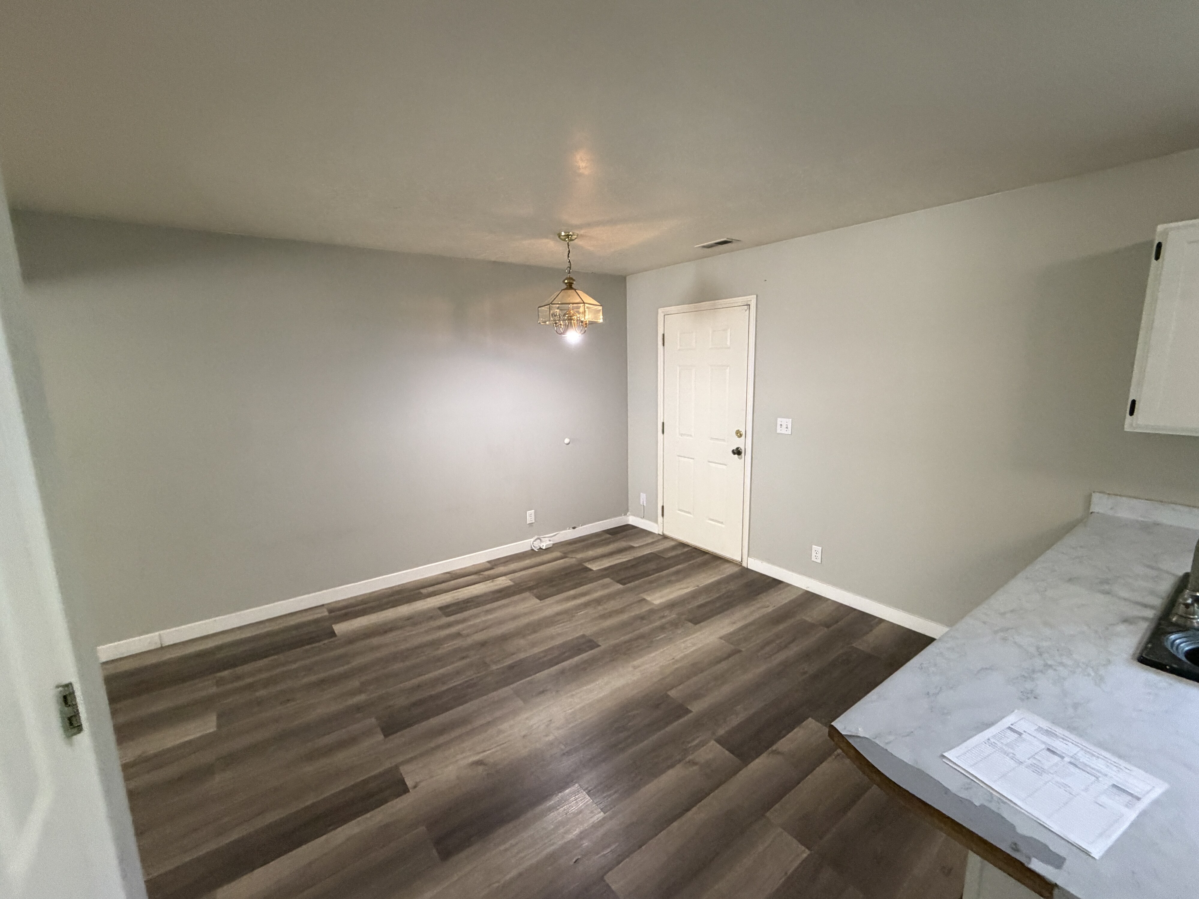 Interior space featuring wood-finish flooring, light gray wall paint, and white baseboards
