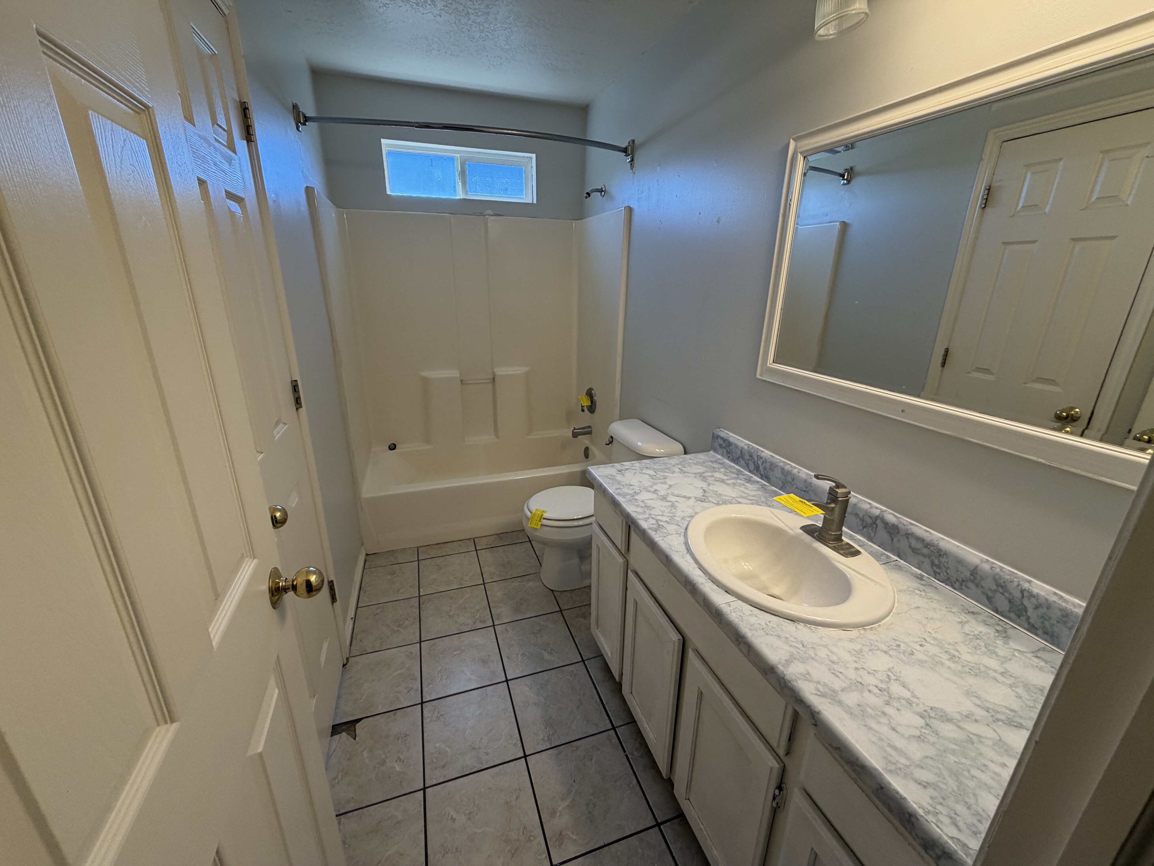 Bathroom featuring a vanity with a patterned countertop, a built-in sink, and a framed mirror