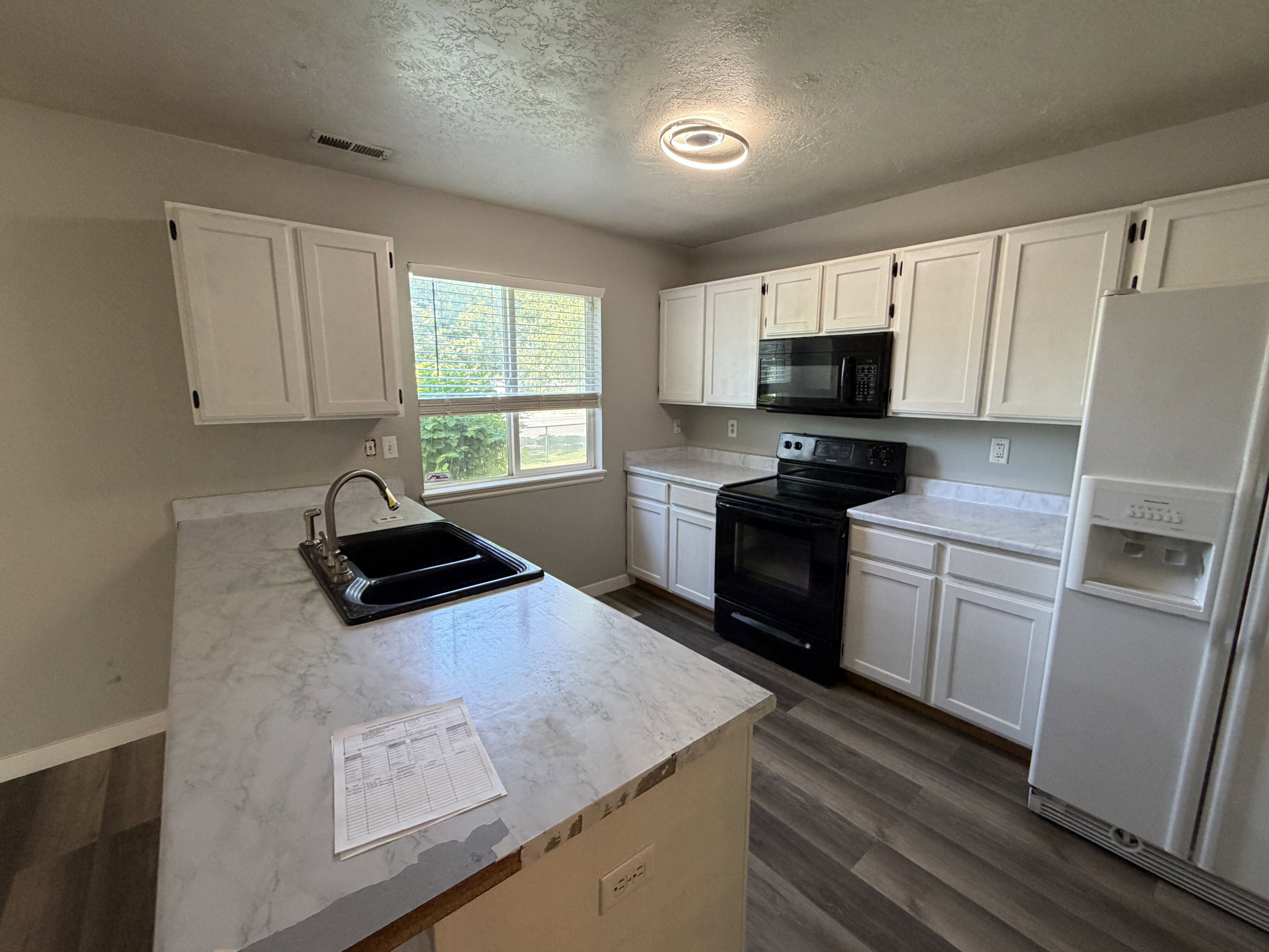 Kitchen featuring white cabinetry and light-toned countertops