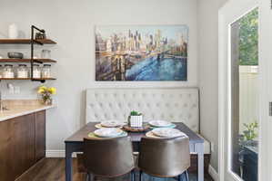 Dining area featuring a built-in upholstered banquette and wood-finish flooring