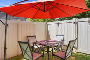 Private outdoor patio space featuring a vinyl privacy fence