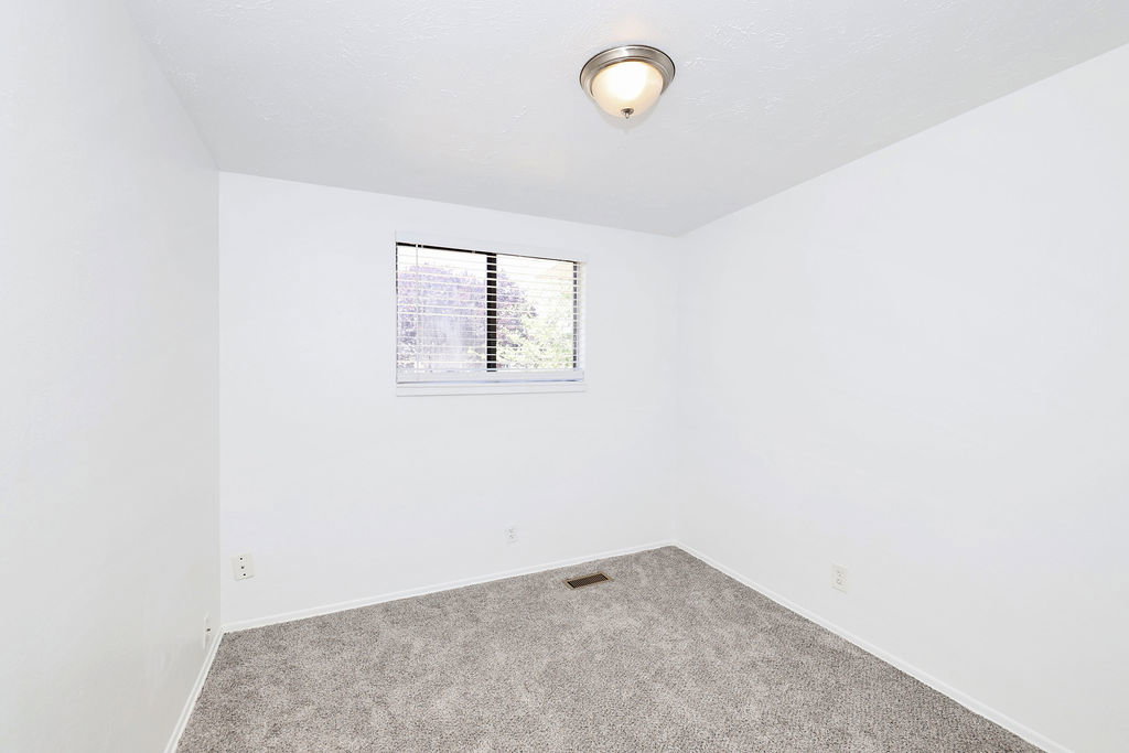 Neutral white walls with textured ceiling and grey carpeting