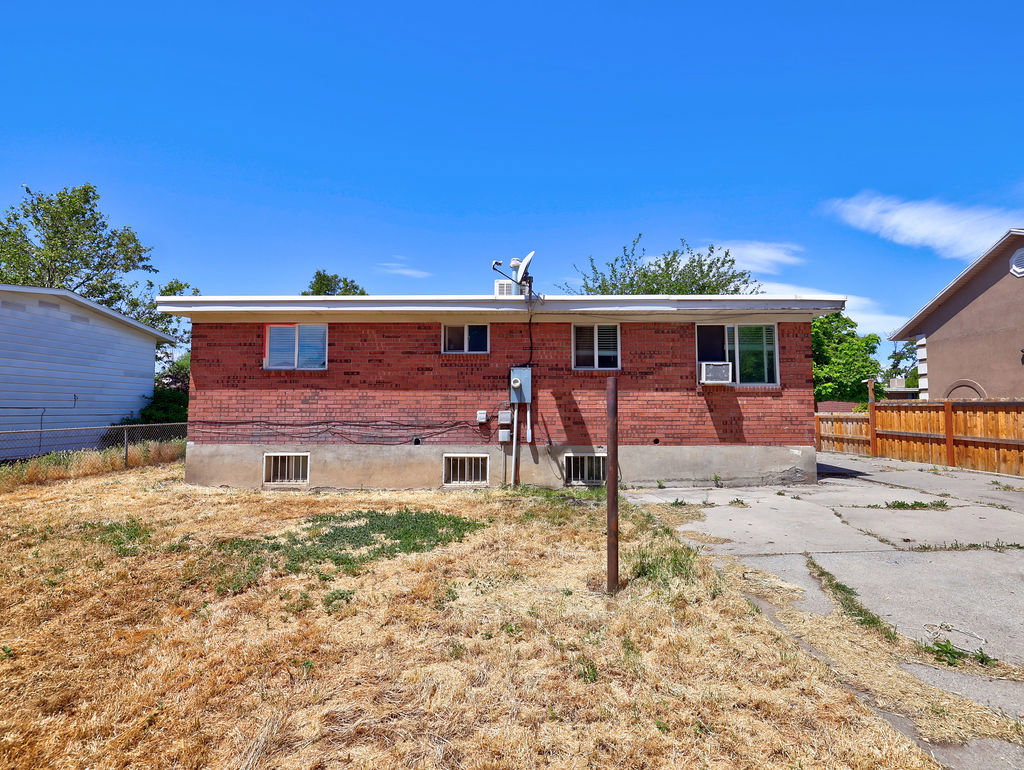 Brick exterior featuring multiple windows and a concrete driveway