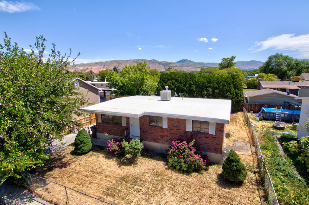 Brick exterior with white trim, featuring a flat roof and an air conditioning unit
