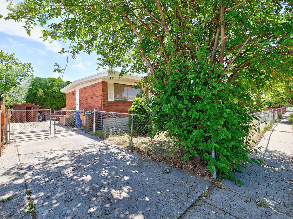 Brick exterior featuring white trim and a chain-link fence