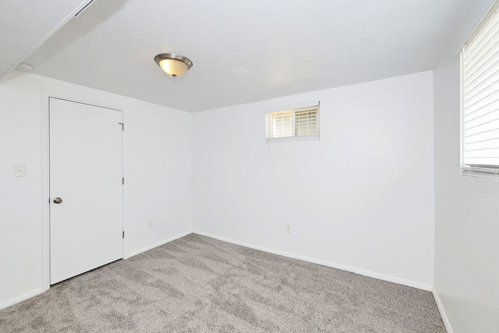 Neutral toned room featuring light gray carpeting and white walls