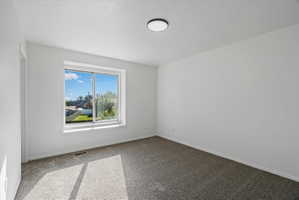 Primary Bedroom Bright interior space featuring a window with a white frame, providing abundant natural light