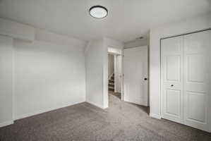 Room featuring light gray carpet, white walls, and a ceiling-mounted light fixture