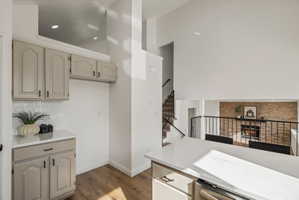Kitchenette with light wood-finish flooring, white countertops, and light gray cabinetry