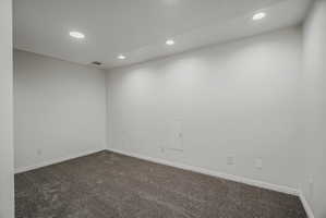 Carpeted room featuring white walls and recessed ceiling lighting