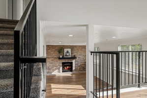 Living space featuring wood-finish flooring and a brick-accented fireplace with a dark mantel