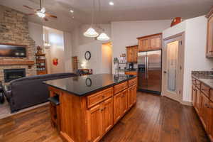 Perfect shot showing the seamless flow from kitchen island to living room and stone fireplace beyond. This is exactly the open layout buyers are looking for.