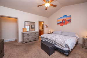 Second angle of the primary suite reveals the walk-in closet entry and ensuite bathroom beyond. Vaulted ceilings add that extra touch of luxury.