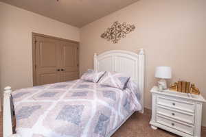 Secondary bedroom showing double closet doors and cozy carpet. A warm, welcoming space ready to make its own.
