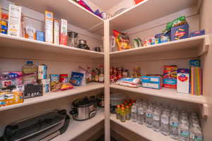 Spacious walk-in pantry with floor-to-ceiling shelving on multiple walls. Room for everything, and then some.
