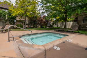 Tucked among mature shade trees, this community hot tub and wading area offers a quiet retreat just steps from the main pool. Surrounded by lounge chairs and lush green space, it's a little slice of resort living right in the neighborhood.